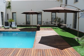 Una piscina al aire libre de temporada, tumbonas