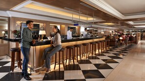 Un espace bar avec un sol à carreaux, des tabourets et un comptoir où le personnel sert des boissons.