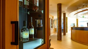 Een hotel receptie met een glazen vitrine waarin drankflessen staan.