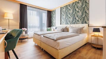 A hotel room with a bed, a desk, a chair, and a large window with curtains.