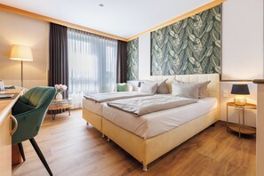 A hotel room with a bed, a desk, a chair, and a large window with curtains. - Weinberghotel Edelacker (Freyburg)