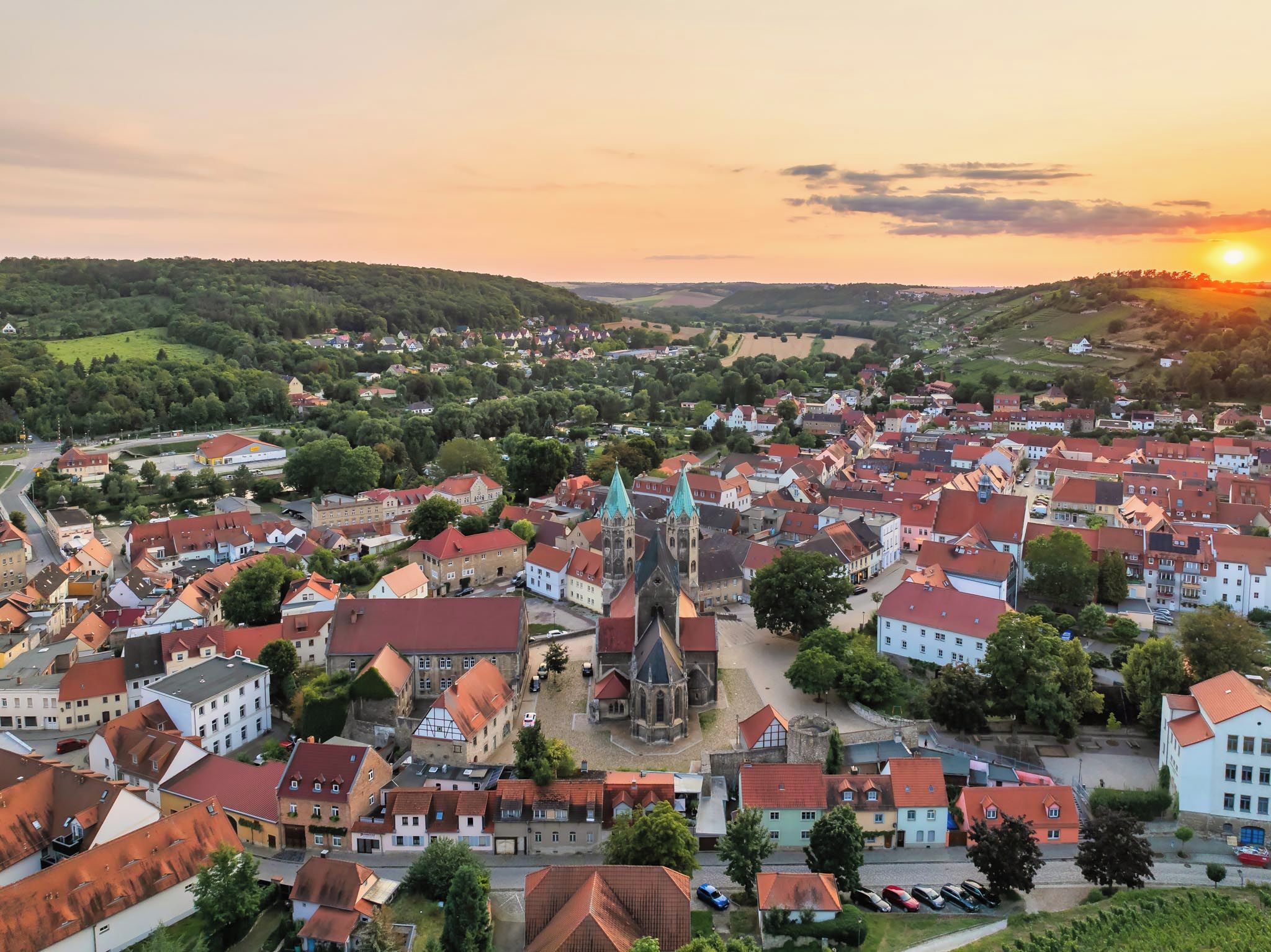A town with historic buildings, a prominent church, and a river.