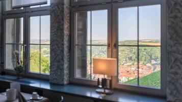 A room with a large window offering a view of a town.