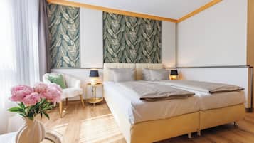 Un dormitorio moderno con una cama grande, lámparas de noche, una mesita y una silla.