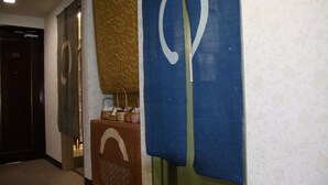 A hallway with a blue and gold patterned wall, a brown wall with a white arch design, and a door labeled '203'. - Miyajima Hotel New Kotobuki (Hatsukaichi)