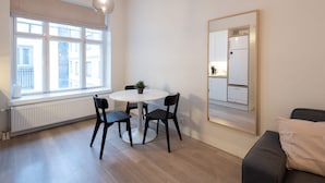 Moderni keittiö, jossa on valkoiset kaapit ja sisäänrakennettu jääkaappi.
