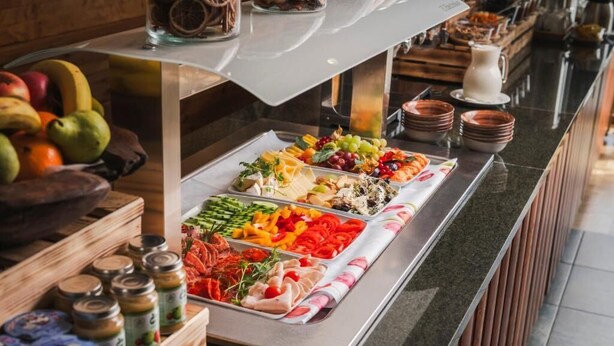 A buffet with various food items including fruits, vegetables, and meats. - Hotel Crocus (Štrba)