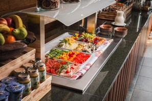 Un buffet con diversi cibi, tra cui frutta, verdura e carni.