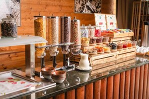 A buffet setup with various food dispensers and a selection of condiments. - Hotel Crocus (Štrba)
