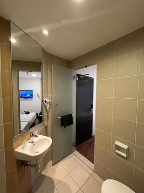 A modern bathroom with a sink, mirror, and toilet. - Sakura Elite Hotel (Kuala Lumpur)