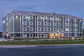 A multi-story hotel with a central entrance, large windows, and a sign indicating it is a Wyndham hotel.