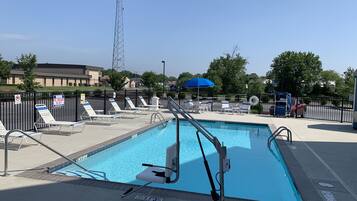 A swimming pool with lounge chairs and a lifeguard stand.