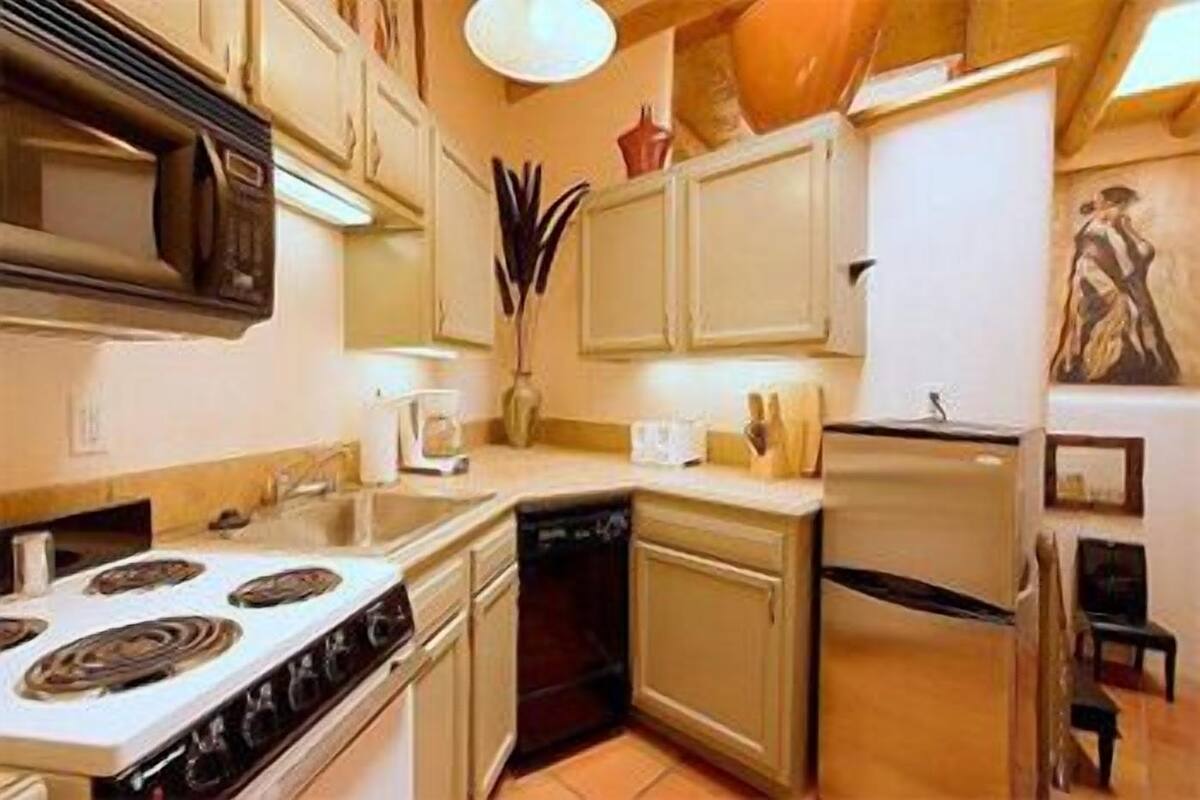 A compact kitchen with a stove, sink, and refrigerator.