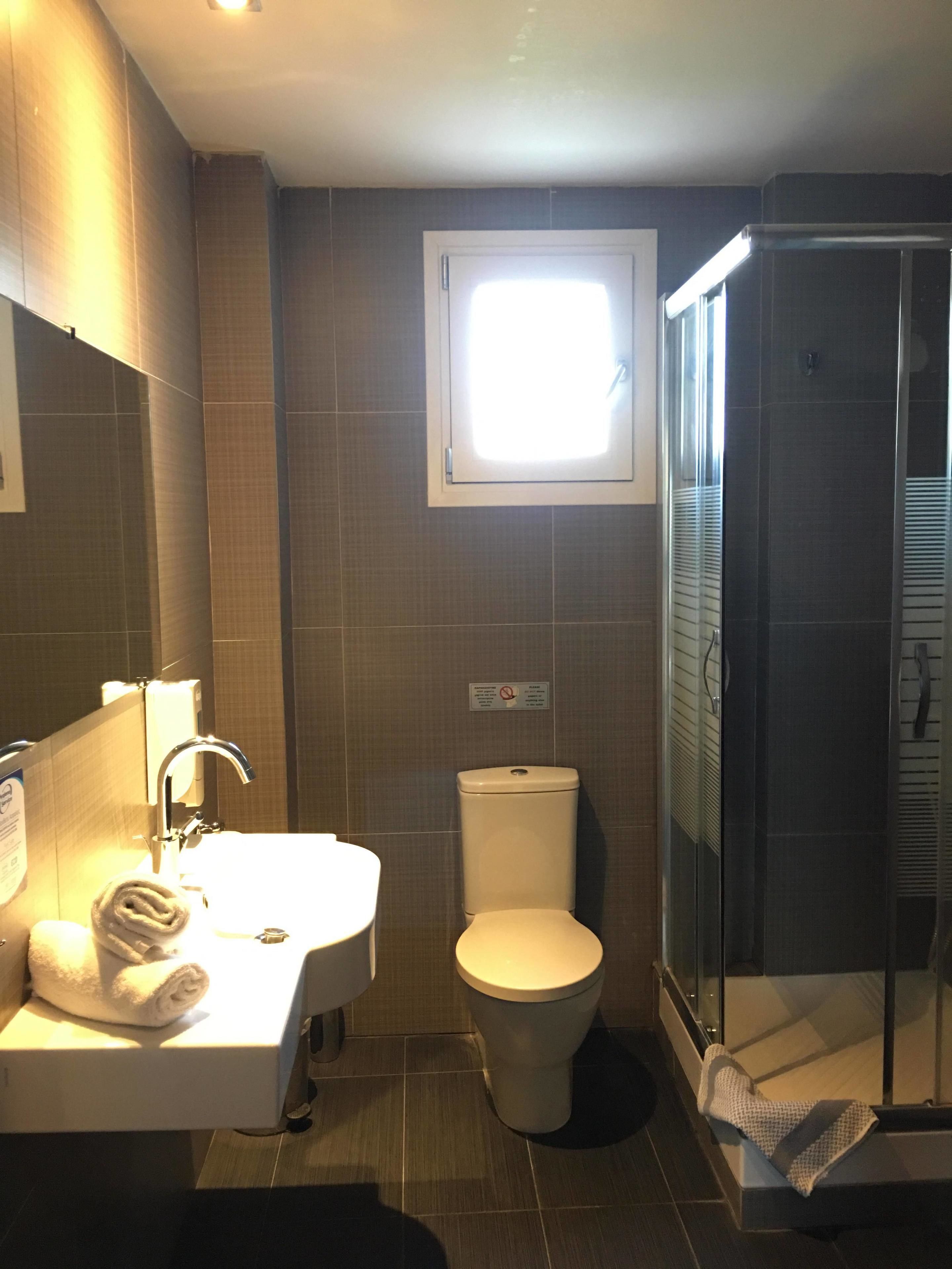 A bathroom with a sink, toilet, and a glass-enclosed shower.