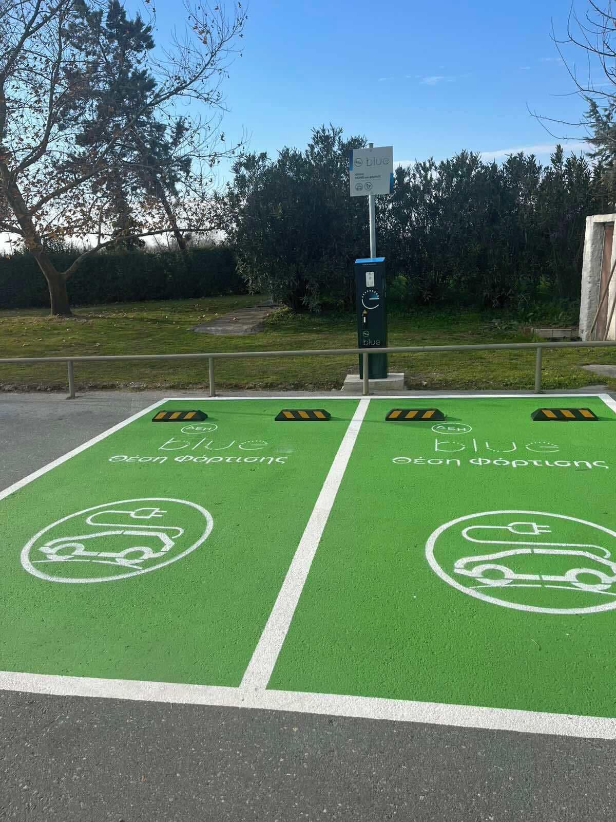 A parking area with green bike lanes and electric vehicle charging stations.