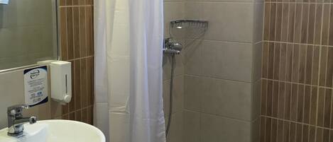 A bathroom with a shower, toilet, and sink.