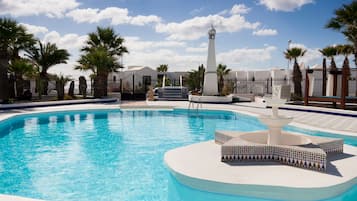 Una piscina al aire libre, sombrillas, tumbonas