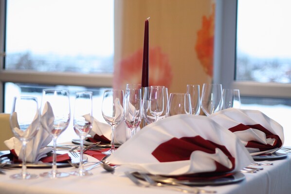 Mesa dispuesta para una cena formal, con varias copas de vino, platos y cubiertos.