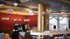 Een bar met verschillende zitplaatsen en een koffieapparaat.