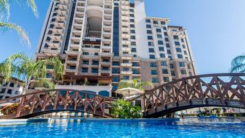 Alberca al aire libre, sombrillas en la alberca y camastros