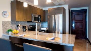 A modern kitchen with a central island, stainless steel appliances, and pendant lighting.