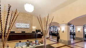 A Croc's Resort Casino lobby with a reception desk, modern decor, and a spacious layout. - Crocs Resort & Casino (Jacó)