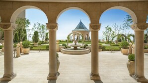 A courtyard with a central fountain, surrounded by columns and arches, leading to a building with a green roof. - The Castle Hotel, a Luxury Collection Hotel, Dalian (Dalian)