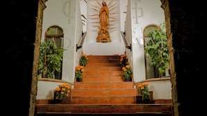 A staircase leading to a religious statue, with potted plants on either side. - Hotel Boutique Hacienda Guadalupe (San Miguel de Allende)