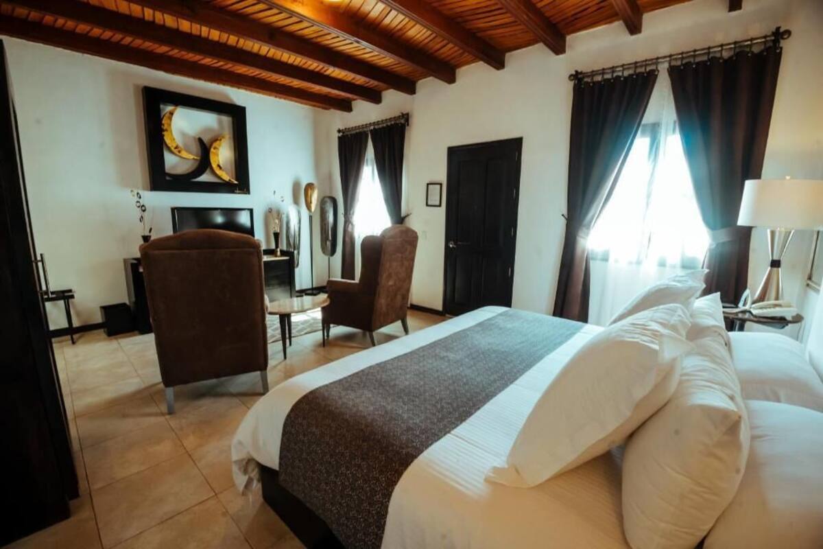 Una habitación de hotel con una cama grande, un escritorio, una silla y un televisor.