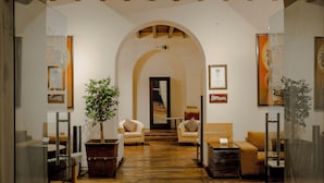 A spacious lobby with a wooden floor, two sofas, a potted plant, and a framed certificate on the wall. - Hotel Boutique Hacienda Guadalupe (San Miguel de Allende)