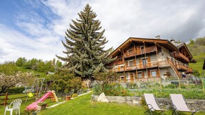 A wooden chalet with balconies, a slide, and a lawn with lounge chairs. - Le Vieux Noyer (Saint-Pierre)