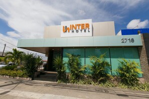 A hotel named 'INTER HOTEL' with a modern facade, large windows, and a number '2716' displayed prominently.