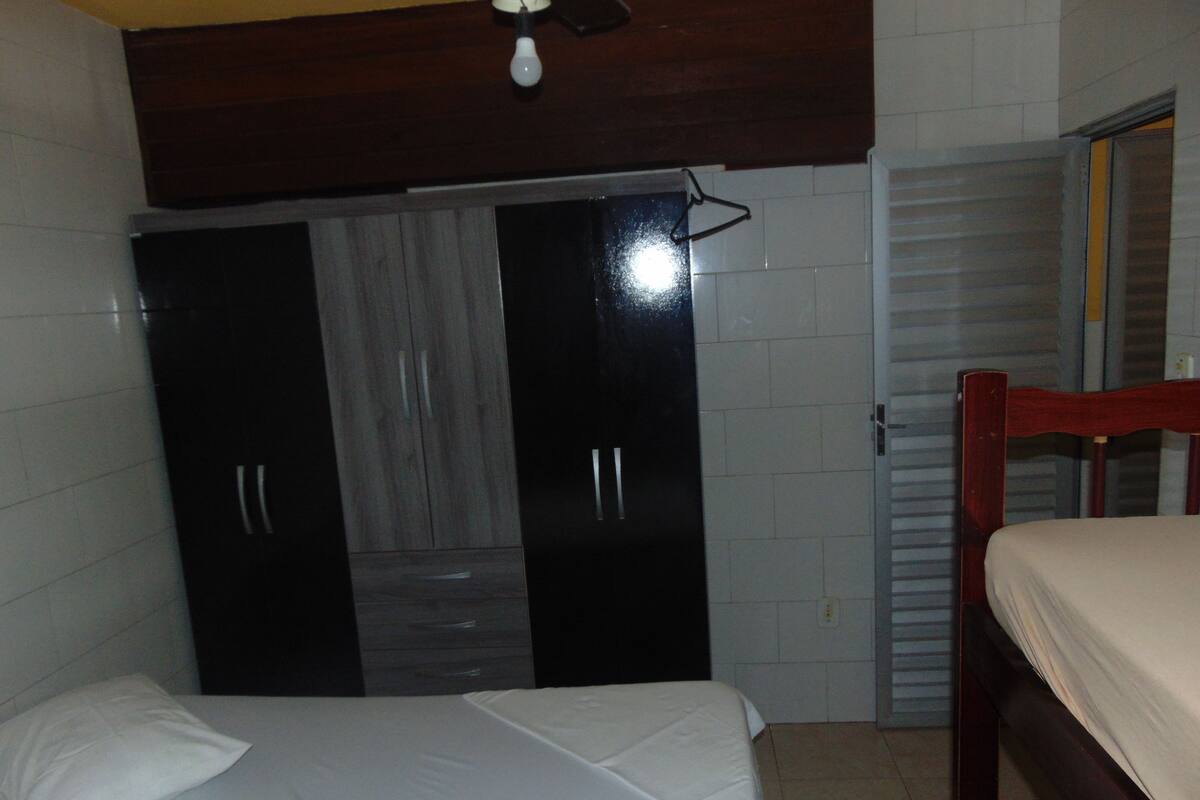 Ein Schlafzimmer mit einem Bett, einem Kleiderschrank und einer Tür.