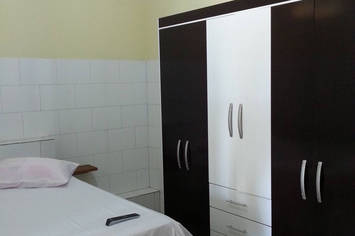 Ein Schlafzimmer mit einem Bett, einem Kleiderschrank und einem Nachttisch.