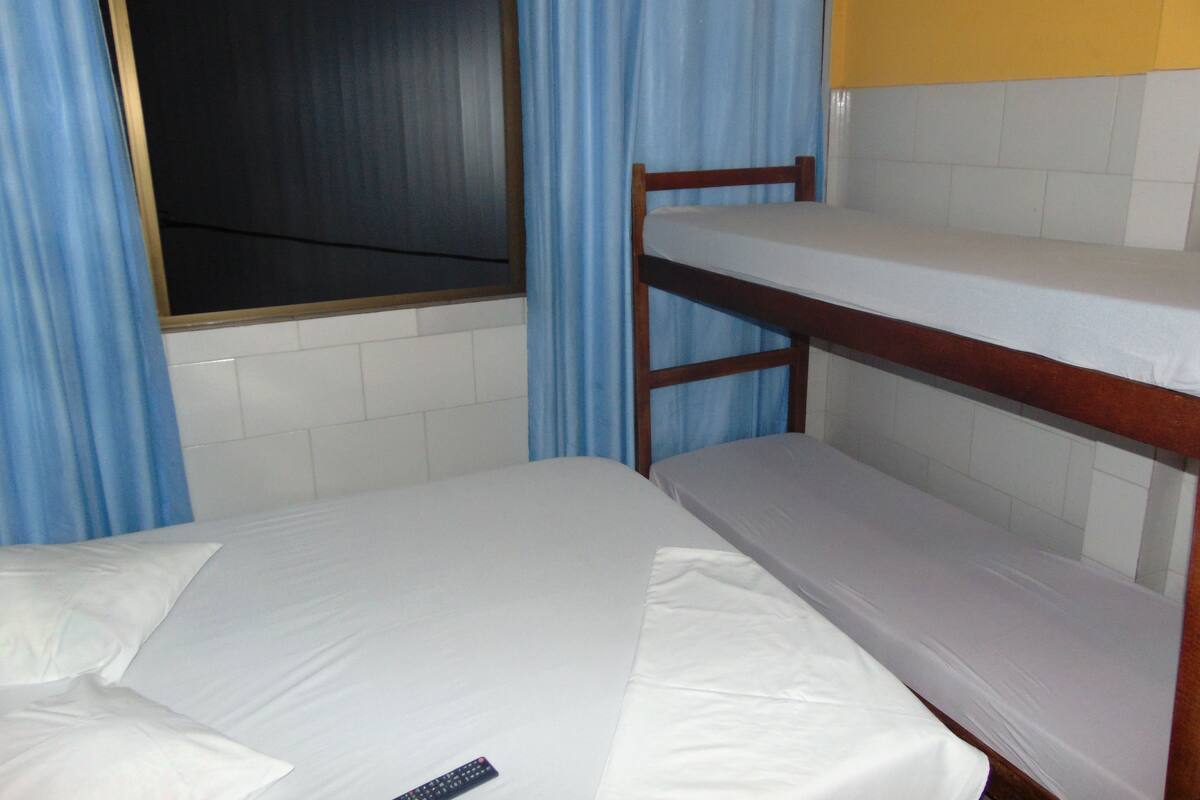 Ein Stockbett mit Holzrahmen und weißer Bettwäsche.