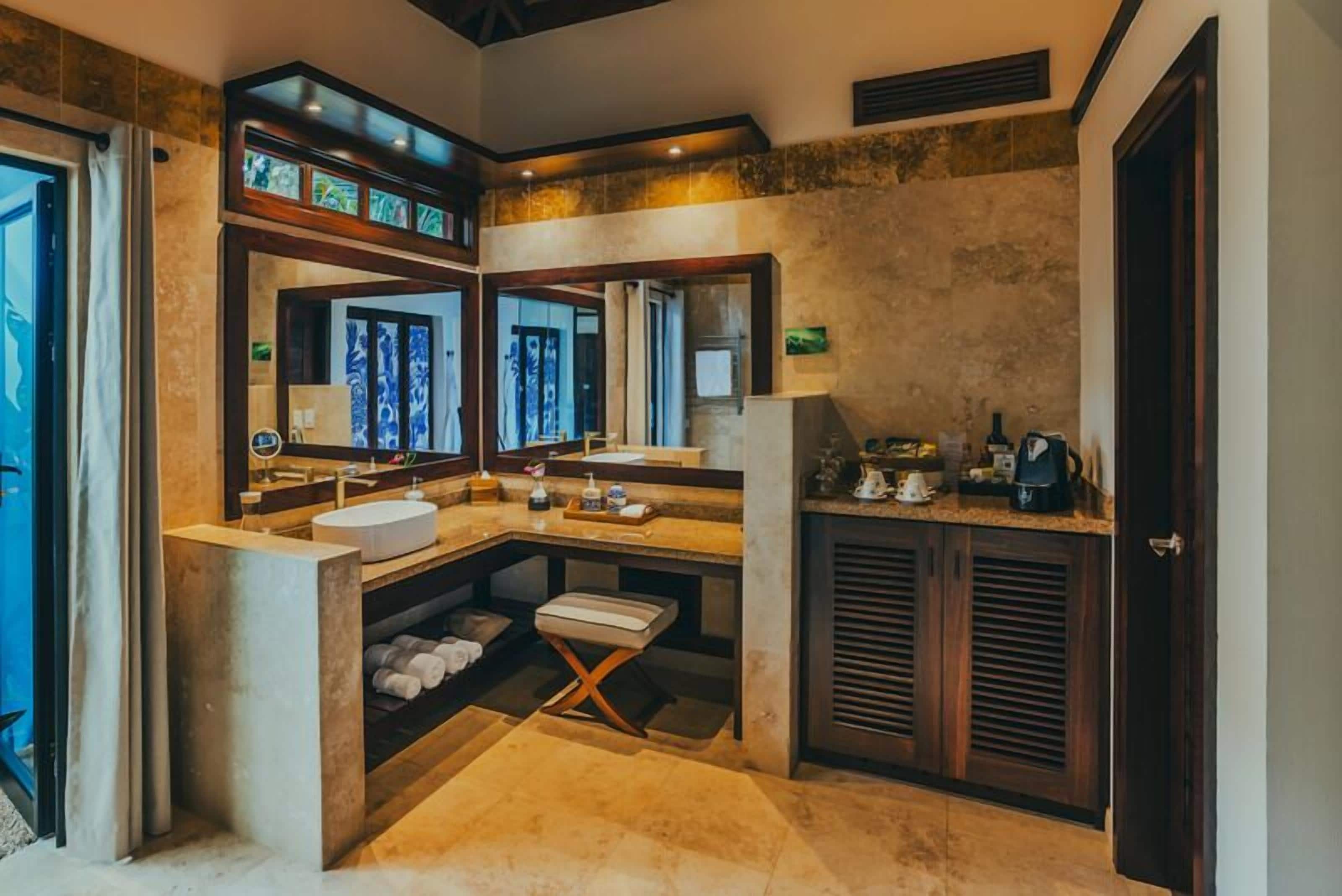 Une salle de bain moderne avec un grand miroir, un lavabo et un meuble-lavabo.