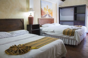 A hotel room with two beds, a large painting on the wall, a lamp, and a wardrobe.
