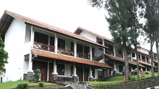 Un edificio de varios pisos con techo de tejas, balcones y pared de piedra.