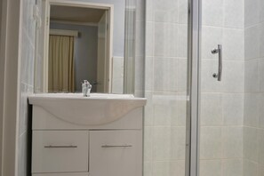 Regadera, secadora de cabello, toallas, papel de baño 