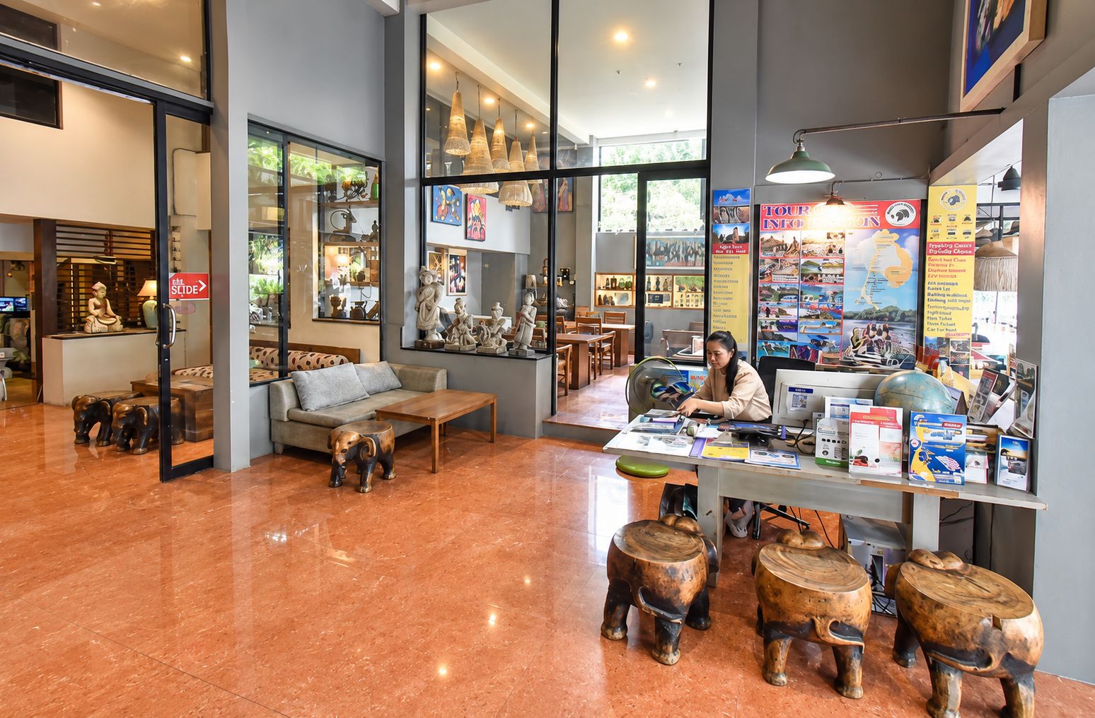 A modern interior with a seating area, a desk with a computer, and various decorative items.