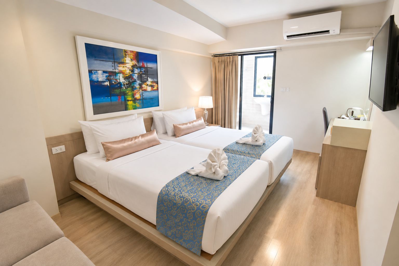 A hotel room with a large bed, a desk, a television, and a painting on the wall.