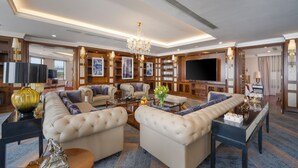A spacious living room with a large sectional sofa, a television, and a chandelier. - Minh Toan Galaxy Hotel (Da Nang)