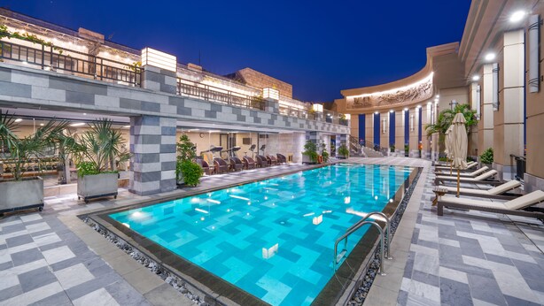 A swimming pool with lounge chairs and a covered seating area. - Minh Toan Galaxy Hotel (Da Nang)