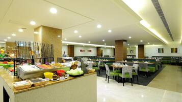Un'area buffet con diversi cibi e un'area salotto con tavoli e sedie.