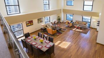 A spacious living area with a dining table set for four, a sofa, and a coffee table.
