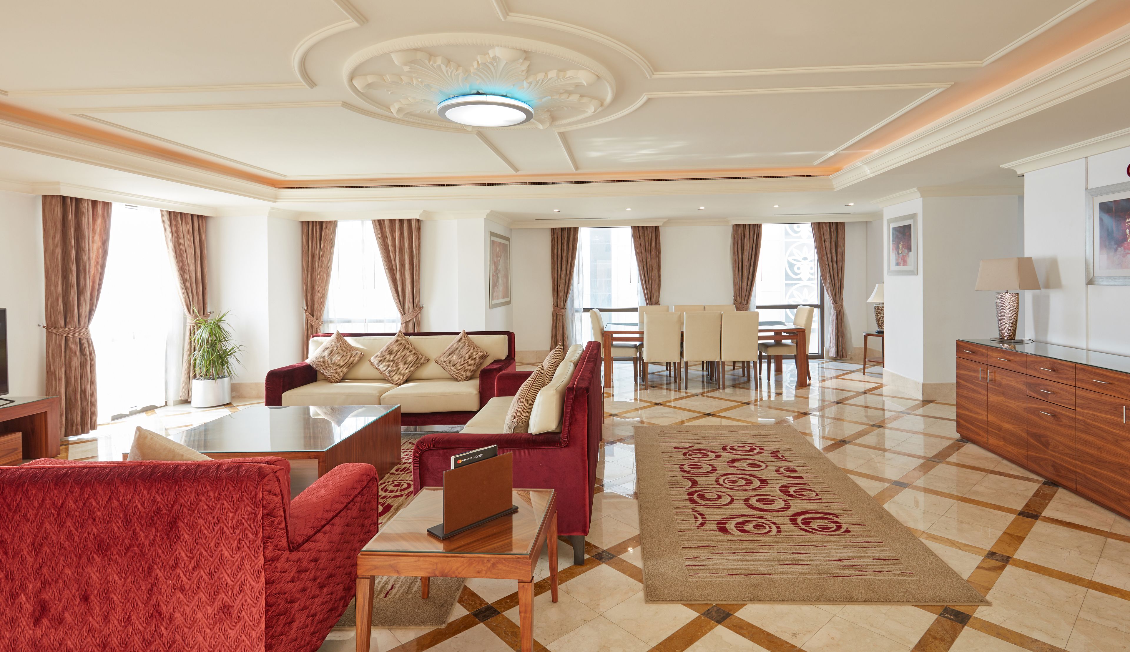 Un amplio espacio de estar con un conjunto de sofás, una mesa de comedor y un televisor.