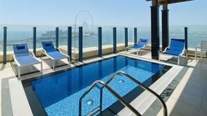 A rooftop pool with blue tiles and a clear view of a Ferris wheel and cityscape. - Roda Amwaj Suites (Dubai)