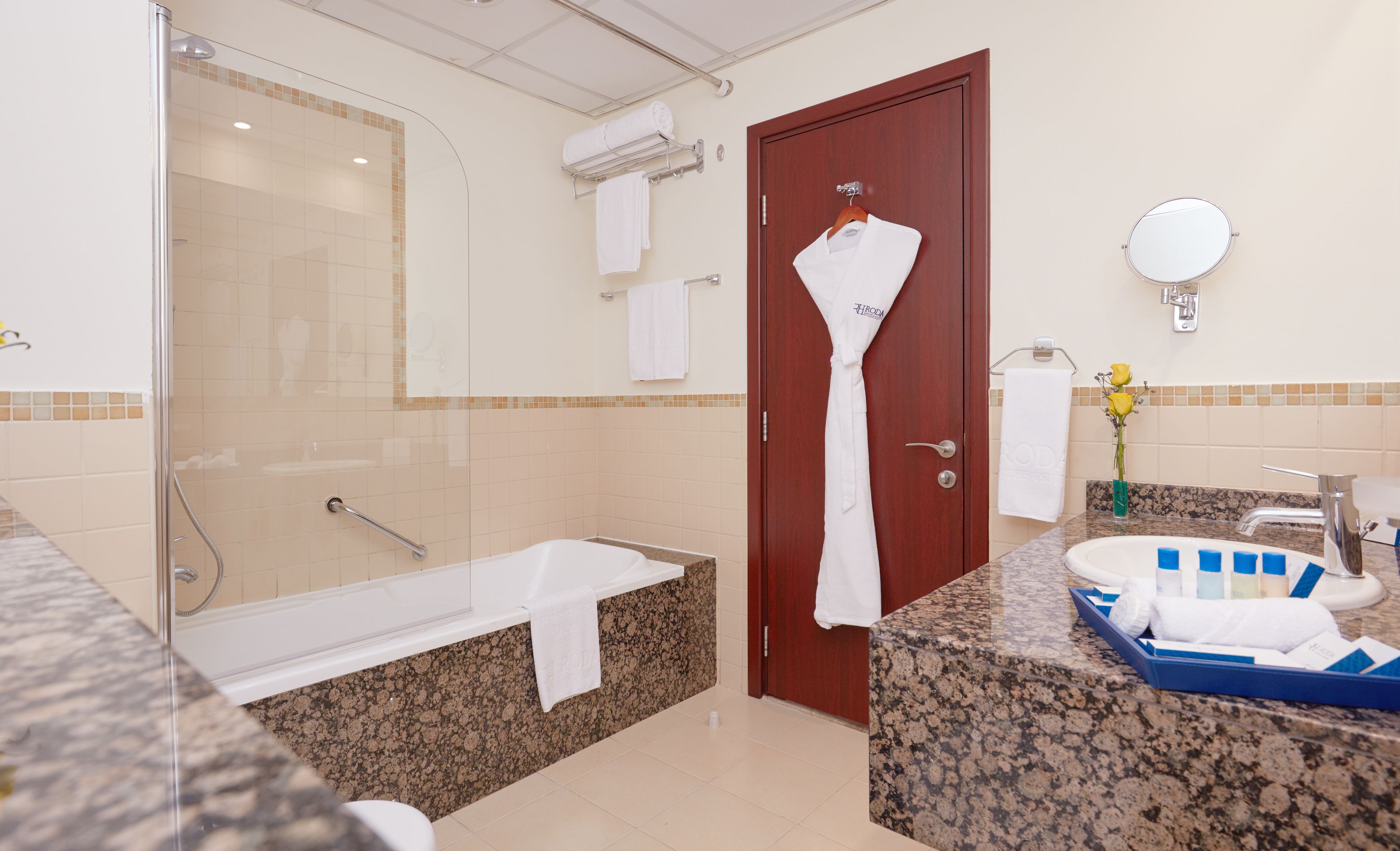 Ein modernes Badezimmer mit Glasdusche, einer Badewanne, einem Waschtisch und einem Spiegel.