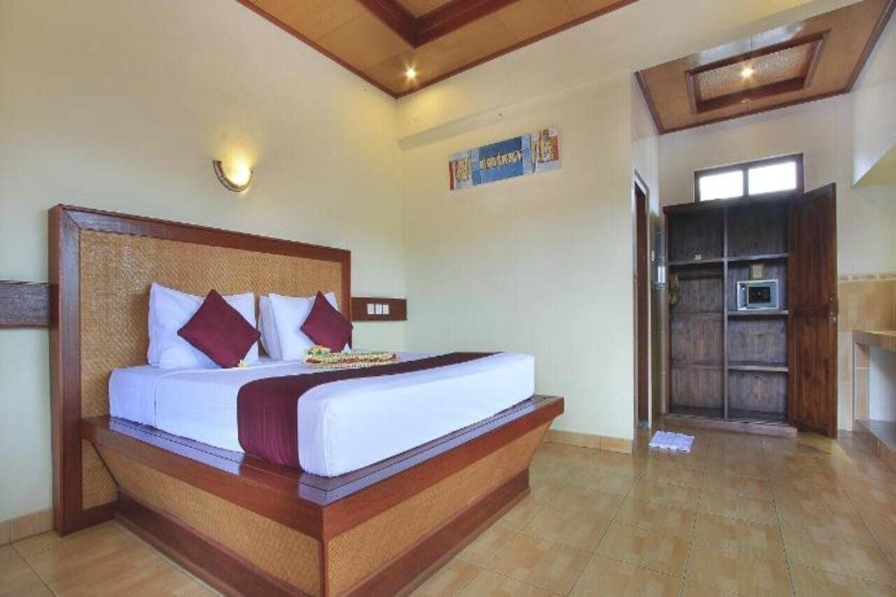 Une chambre spacieuse avec un grand lit, une tête de lit en bois et une armoire intégrée.