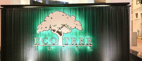 Un letrero de hotel con un logotipo de árbol y el nombre 'Eco Tree Hotel'.